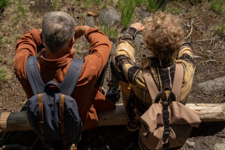 Grandfather and grandson enjoying a summer hike, sitting together in the forest.