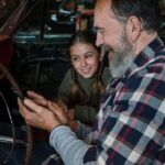 Father and daughter enjoy bonding time in a vintage car, sharing smiles and togetherness.