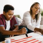 Mother and son enjoy quality time painting a school project at home.